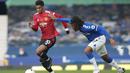 Penyerang Manchester United, Marcus Rashford, berebut bola dengan gelandang Everton, Alex Iwobi, pada laga lanjutan Liga Inggris di Goodison Park Stadium, Sabtu (7/11/2020) malam WIB. Manchester United menang 3-1 atas Everton. (Clive Brunskill/Pool via AP)