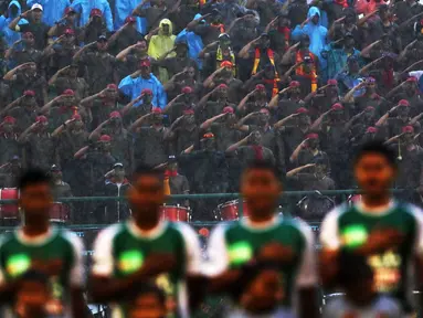 Suporter PS TNI melakukan penghormatan saat menyanyikan lagu Indonesia Raya bersama pemain PS TNI pada laga Piala Jenderal Sudirman di Stadion Manahan, Solo, Sabtu (12/11/2015). (Bola.com/Nicklas Hanoatubun)