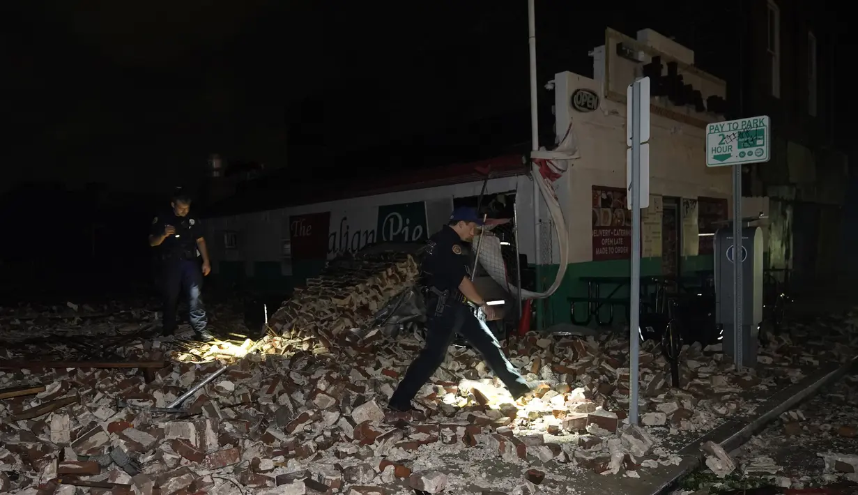 Polisi memeriksa puing-puing setelah sebuah bangunan runtuh akibat dampak Badai Ida di New Orleans, Louisiana, Senin (30/8/2021). Badai Ida ini sebagai salah satu badai paling kuat yang pernah melanda Amerika Serikat.  (AP Photo/Eric Gay)