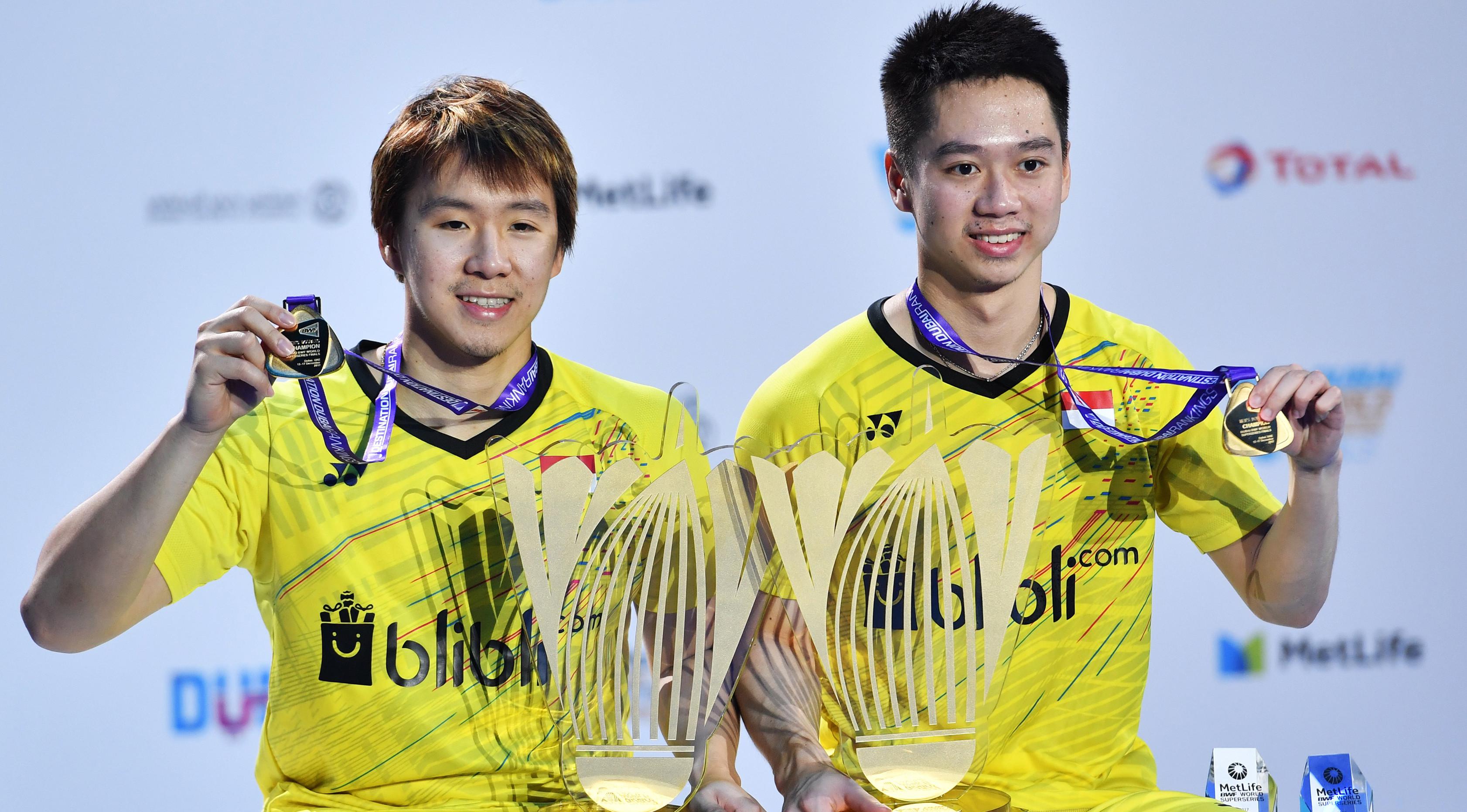 Pebulutangkis ganda putra Indonesia, Marcus Fernaldi Gideon dan Kevin Sanjaya Sukamuljo berpose menunjukkan medali mereka usai bertanding pada final BWF Dubai Super Series Finals 2017 di Hamdan Sports Complex, Dubai, Minggu (17/12). (GIUSEPPE CACACE/AFP)
