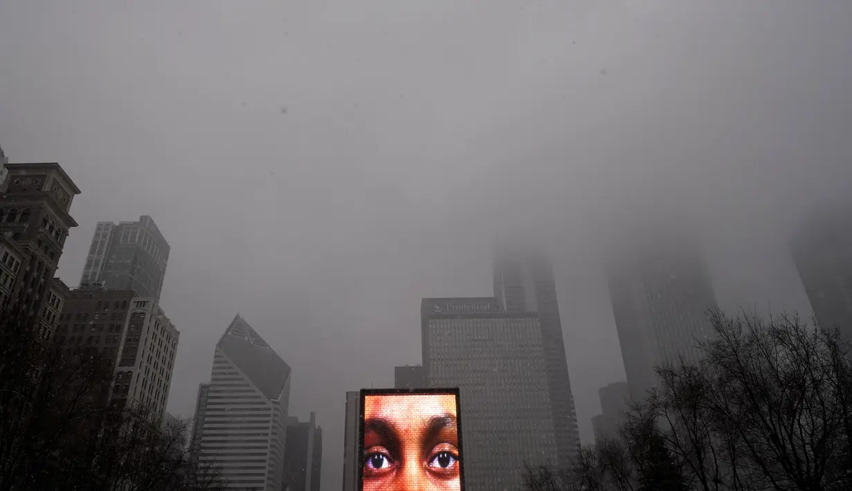 Mata dari wajah yang diproyeksikan pada salah satu dari dua monolit Crown Fountain terlihat saat langit kelabu di Millennium Park Chicago, Kamis (4/2/2021).  Badai musim dingin terus menambah salju yang sudah menumpuk di Chicago. (AP Photo/Charles Rex Arbogast)