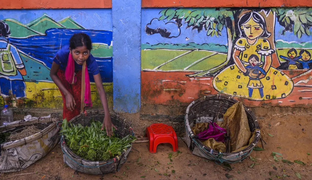 Seorang anak Rohingya menjual sayuran di Kamp Pengungsi Kutupalong di Cox's Bazar, Bangladesh, Senin (22/7/2019). Lebih dari satu juta etnis Rohingya melarikan diri dari Myanmar dan menetap di Kutupalong yang merupakan salah satu kamp pengungsi terbesar di dunia. (MUNIR UZ ZAMAN/AFP)