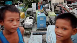 Anak-anak bermain di kuburan bergaya apartemen yang dibangun di North Cemetery, Manila, Minggu (16/10). Pemakaman ini menjadi lokasi penguburan korban tewas dalam perang melawan narkoba di Filipina. (Reuters/Damir Sagolj)