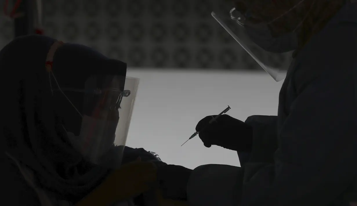 Seorang wanita menerima suntikan vaksin Sinovac saat vaksinasi massal virus corona COVID-19 untuk umum di Patriot Candrabhaga Sadium, Bekasi, Jawa Barat, Senin (14/6/2021). Peminat vaksinasi COVID-19 di Stadion Patriot Candrabagha sangat tinggi. (AP Photo/Achmad Ibrahim)