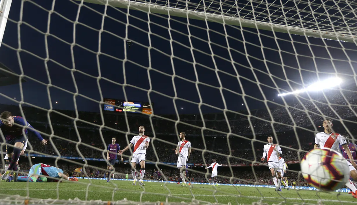 Bek Barcelona, Gerard Pique, membobol gawang Rayo Vallecano pada laga La Liga di Stadion Camp Nou, Sabtu (9/3). Barcelona menang 3-1 atas Rayo Vallecano. (AP/Manu Fernandez)