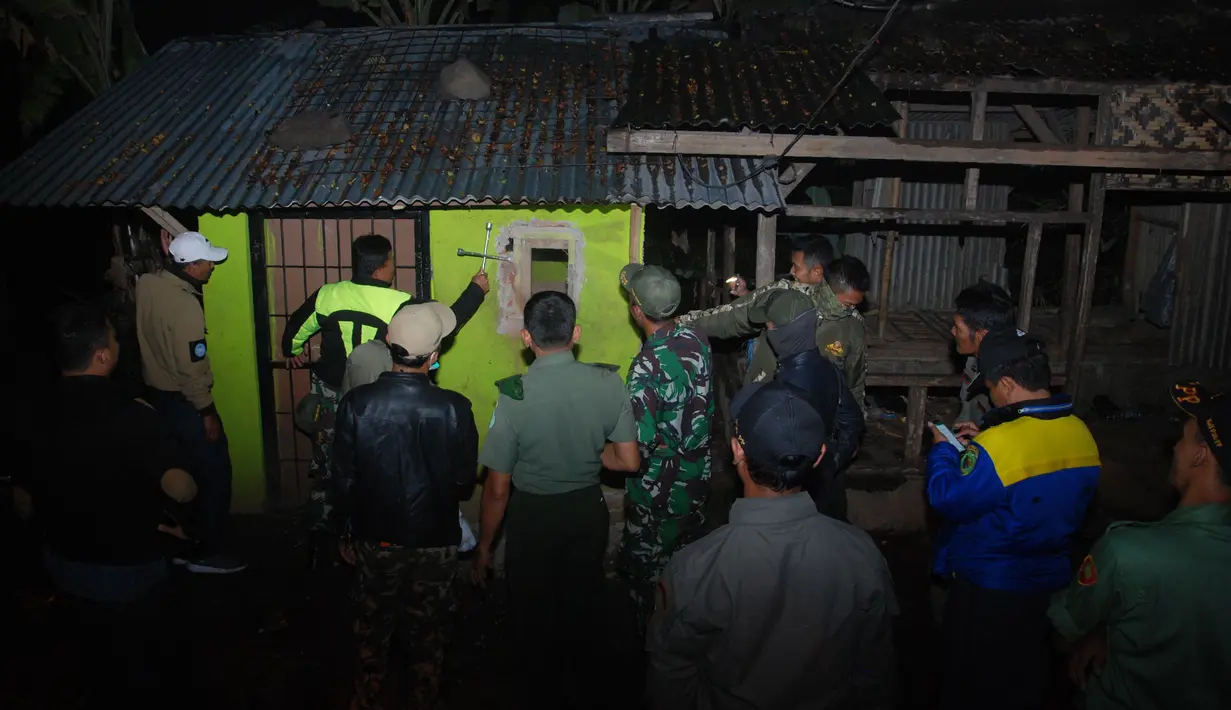 Petugas  menggerebek tempat penjualan dan pembuatan miras di Cicalengka, Kabupaten Bandung, Minggu (8/4). Penggerebekan toko miras di enam titik wilayah Cicalengka dilakukan pasca meninggalnya 15 orang akibat menenggak miras oplosan. (Timur Matahari/AFP)