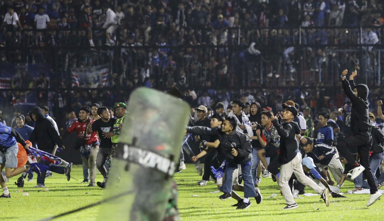 Kericuhan tak terelakkan di stadion yang menjadi markas Arema FC itu. Aremania turun ke lapangan setelah tim kesayangan mereka kalah dari rival bebuyutannya. (AP/Yudha Prabowo)