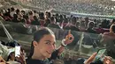 Paula Verhoeven terlihat berfoto selfie di tribun saat menonton konser Coldplay Jakarta. Ia mengenakan atasan kaus lengan pendek berwarna hitam. Rambutnya ditata sleek look dan wajah dirias minimalis. [Foto: Instagram/paula_verhoeven]