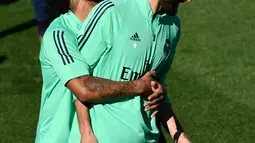 Bek Real Madrid Marcelo (kiri) bercanda dengan penyerang Karim Benzema saat sesi latihan di kompleks latihan Valdebebas, Madrid, Spanyol, Senin (30/9/2019). Real Madrid bersiap jelang menjamu Club Brugge dalam laga Liga Champions. (PIERRE-PHILIPPE MARCOU/AFP)