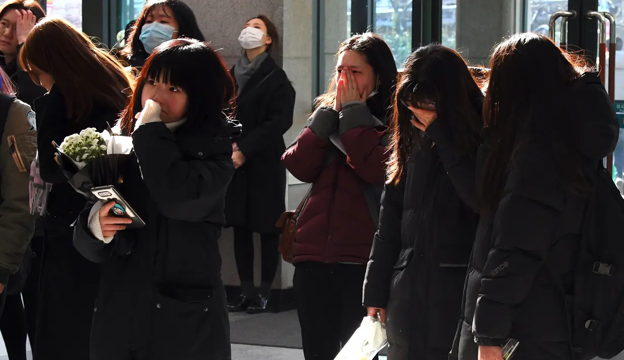 Para fans menangis saat datang memberikan penghormatan kepada Jonghyun SHINee di rumah duka Seoul Asan Hospital, Selasa (19/12). SM Entertainment dan keluarga Jonghyun memutuskan untuk memberi kesempatan bagi para fans untuk melayat. (JUNG Yeon-Je / AFP)