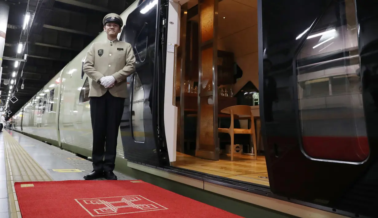 Kru berdiri di samping kereta api mewah "Train Suite Shiki-Shima" di Stasiun Ueno, Tokyo, Jepang, 16 Maret 2017. Kereta dengan panjang 10 gerbong itu, hanya berisi 34 penumpang eksklusif guna menikmati pemandangan indah di luar sana. (str/JIJI PRESS/AFP)