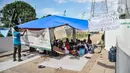 Warga memasang spanduk saat membangun tenda pengungsian di depan gerbang Kampung Susun Bayam, Jakarta Utara, Senin (21/11/2022). Aksi tersebut dilakukan untuk menagih janji PT Jakpro dan Pemprov DKI Jakarta agar warga bisa segera menempati Kampung Susun Bayam secepatnya. (merdeka.com/Iqbal S. Nugroho)