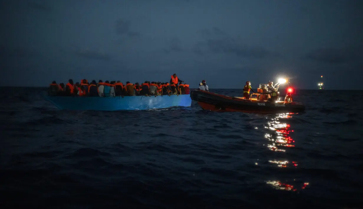 LSM Spanyol Open Arms menolong imigran di Laut Mediterania, Selasa (8/9/2020). Puluhan imigran termasuk wanita dan anak-anak asal Mesir, Maroko, Somalia, dan Sierra Leone menghabiskan lebih dari 20 jam saat melarikan diri dari Libya dengan kapal kayu. (AP Photo/Santi Palacios)