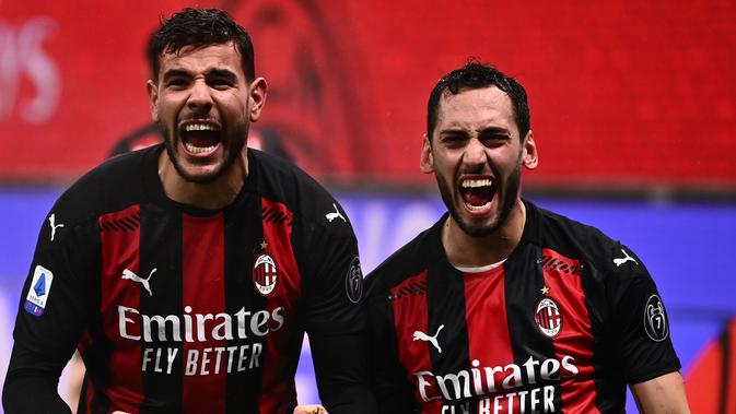 Pemain AC Milan Theo Hernandez merayakan golnya ke gawang Lazio bersama Hakan Calhanoglu pada pertandingan Serie A di San Siro, Kamis (24/12/2020) dini hari WIB. (AFP/Marco Bartorello)