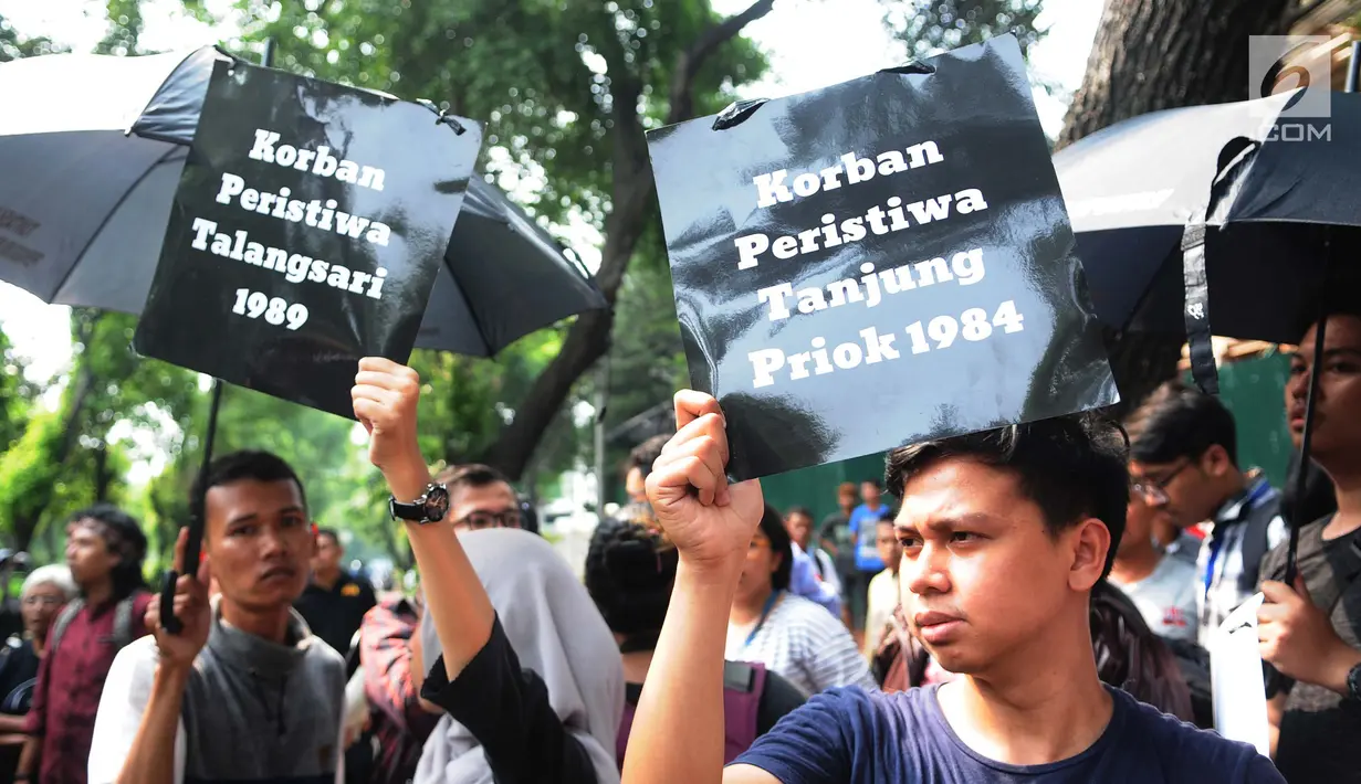 Aktivis HAM membawa sejumlah poster saat menggelar aksi di depan kantor Komnas HAM di Jakarta, Selasa (11/12). Aktivis menuntut penyelesaian kasus pelanggaran HAM yang terjadi di Indonesia. (Liputan6.com/Angga Yuniar)