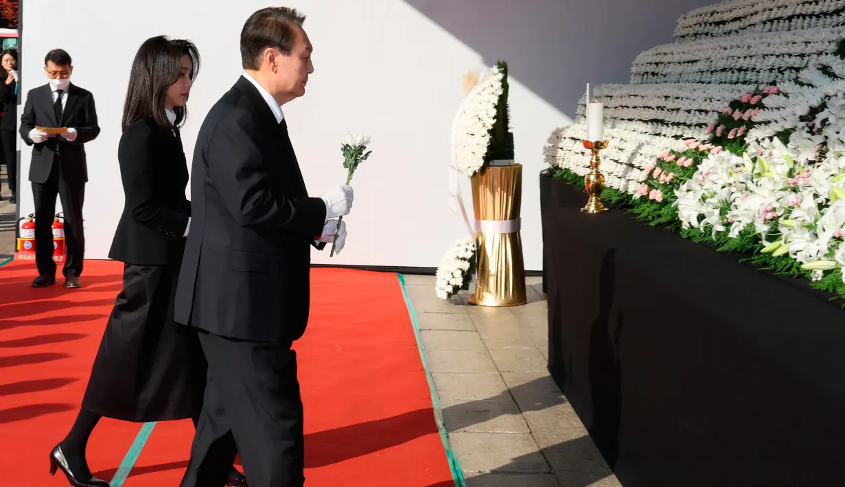 Presiden Korea Selatan Yoon Suk-yeol dan istrinya Kim Keon-hee tiba untuk memberikan penghormatan kepada para korban tragedi Halloween Itaewon di altar peringatan bersama untuk para korban di Seoul Square, Seoul, Korea Selatan, Senin (31/10/2022). Tragedi Halloween Itaewon menewaskan lebih dari 150 orang dan menjadi bencana terburuk Korea Selatan dalam beberapa tahun. (Ahn Jung-hwan/Yonhap via AP)