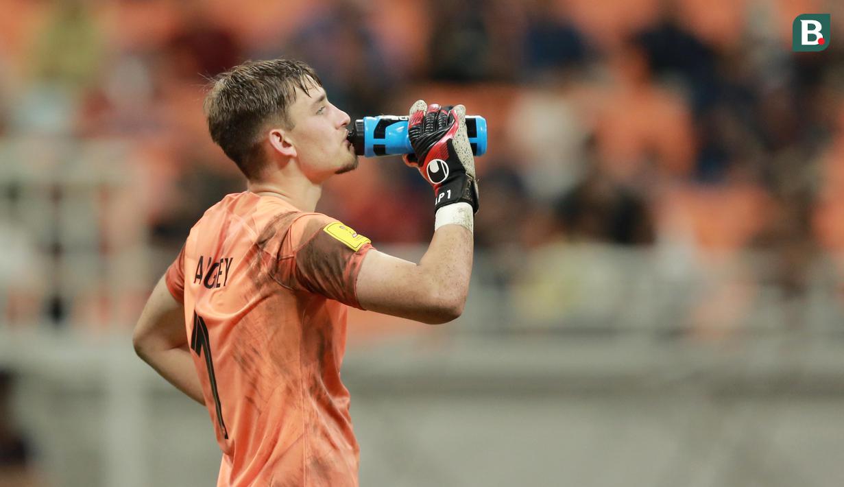Kiper Timnas Prancis U-17, Paul Argney, meminum air dari botol saat adu penalti melawan Senegal U-17 pada babak 16 besar Piala Dunia U-17 2023 di Jakarta International Stadium (JIS), Rabu (22/11/2023). Prancis menjadi satu-satunya kontestan yang belum kebobolan sejak fase grup berkat aksi heroik sang kiper, Paul Argney. (Bola.com/M Iqbal Ichsan)