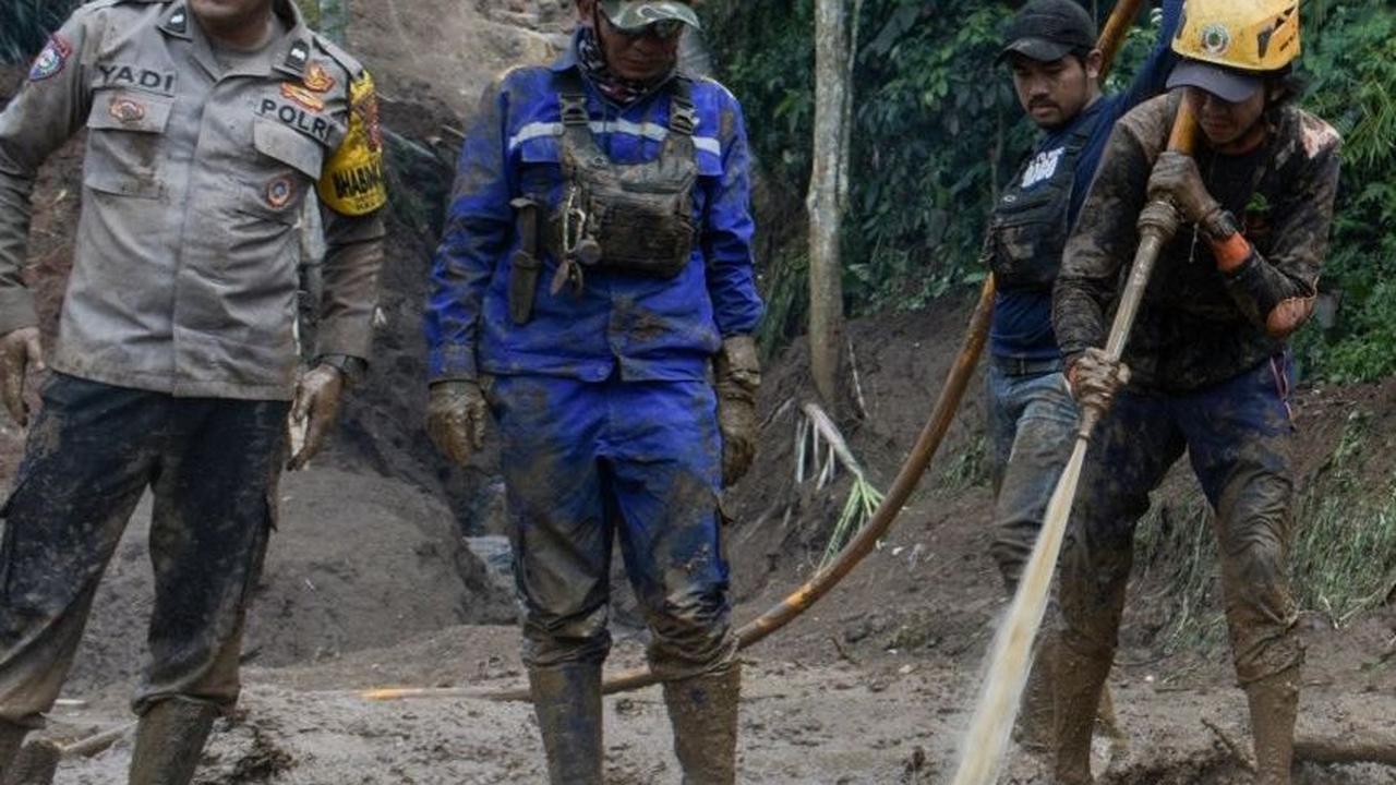 Kondisi ini membuat pencarian dilakukan secara manual dengan melakukan penyemprotan ke material tanah menggunakan air. Foto: TIMUR MATAHARI / AFP<br>