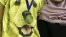 Praveen Jordan mengenakan kaos bergambar anjing dengan medali emas All England saat tiba di Bandara Soekarno-Hatta, Tangerang, Rabu (16/3/2016).  (Bola.com/Nicklas Hanoatubun)