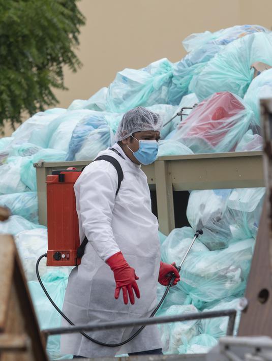 Petugas medis mengenakan alat pelindung diri saat mendisinfeksi limbah biologis berbahaya di luar Rumah Sakit del Instituto Mexicano del Seguro Social, Veracruz, Meksiko, Rabu (12/8/2020). Pembuangan limbah medis yang tidak tepat menjadi masalah di tengah pandemi COVID-19. (AP Photo/Felix Marquez)