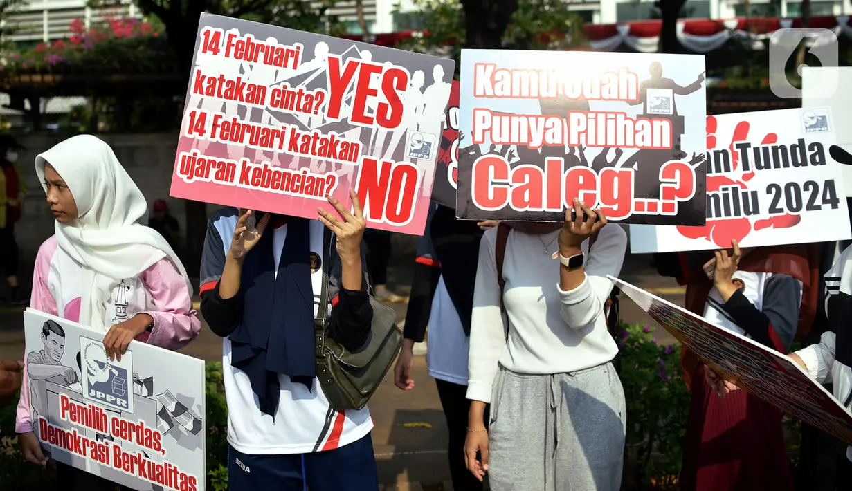 Sejumlah warga membawa poster bertuliskan sosialisasi Pemilu 2024, saat Hari Bebas Kendaraan Bermotor (HBKB) di kawasan Bundaran HI, Jakarta, Minggu (20/8/2023). (Liputan6.com/Johan Tallo)