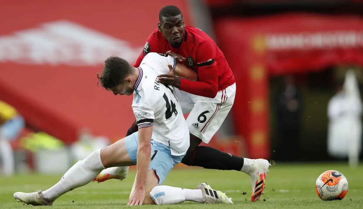 Pemain Manchester United Paul Pogba (kanan) berebut bola dengan pemain West Ham United Declan Rice pada pertandingan Liga Inggris di Old Trafford, Manchester, Inggris, Rabu (22/7/2020). Pertandingan berakhir dengan skor 1-1. (Clive Brunskill/Pool via AP)