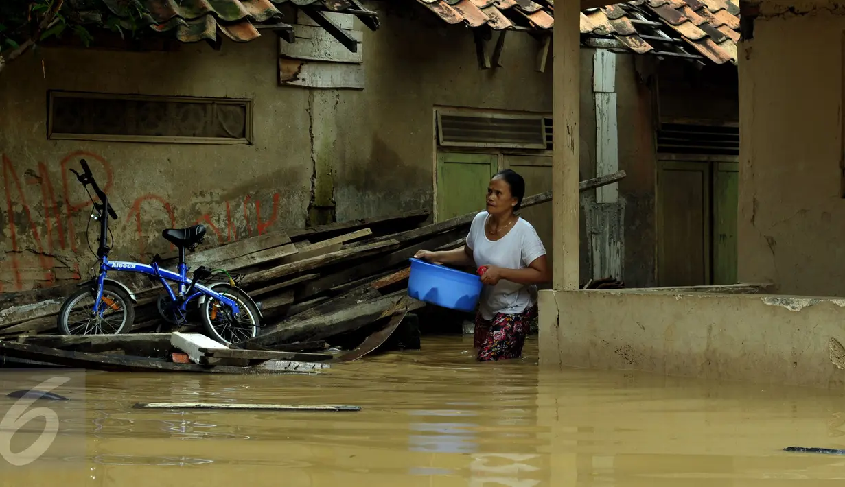Warga keluar dari dalam salah satu gang yang ada di kawasan Rawajati, Jakarta, Selasa (8/3/2016). Akibat banjir kiriman dari Bogor, ratusan rumah di kawasan Rawajati Kalibata terendam hingga kedalaman 120cm. (Liputan6.com/Helmi Fithriansyah)