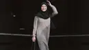 <p>Awkarin mengunggah beberapa potret dirinya yang akhirnya pergi menjalankan ibadah Umroh bersama keluarga dan sahabat. Di sini, Awkarin tampil manis mengenakan gamis abu-abu dan hijab hitam serba polos. [Foto: Instagram/narinkovilda]</p>