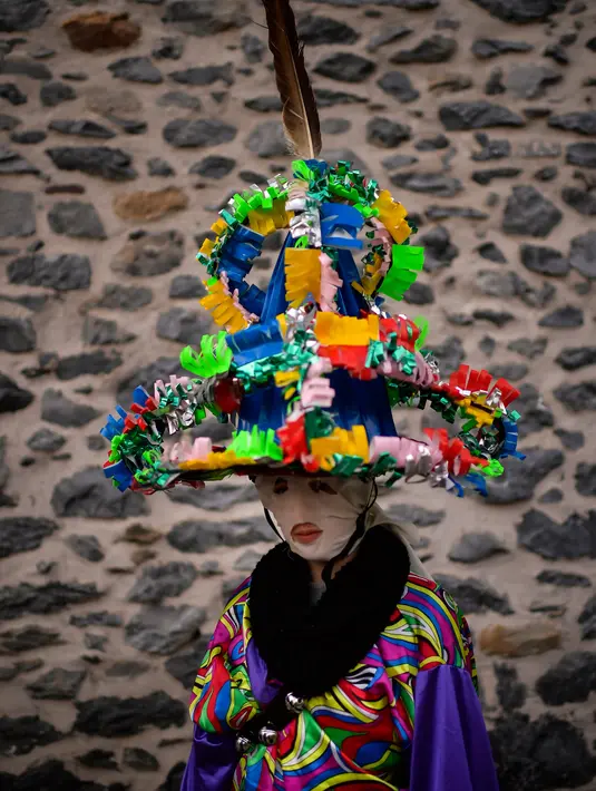 Seorang peserta mengenakan pakaian tradisional dan topi yang dikenal sebagai '' Ttutturo '' berpose di sela acara karnaval di desa Pyrenees Leitza, Spanyol (30/1). (AP Photo / Alvaro Barrientos)