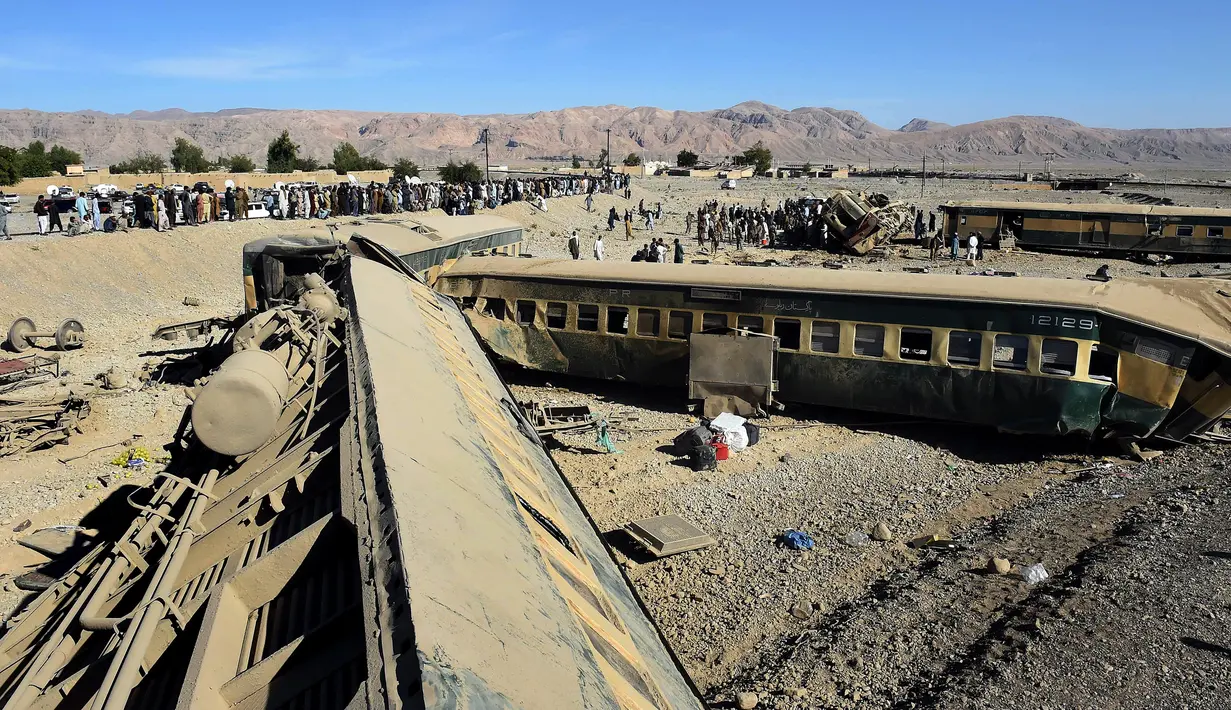 Tim penyelamat memeriksa gerbong kereta api yang tergelincir dari rel di daerah pegunungan Bolan dekat Quetta dalam perjalanan ke Rawalpindi, Pakistan, Selasa (17/11). Sedikitnya 12 orang tewas dalam kecelakaan tersebut. (AFP PHOTO/BANARAS KHAN)