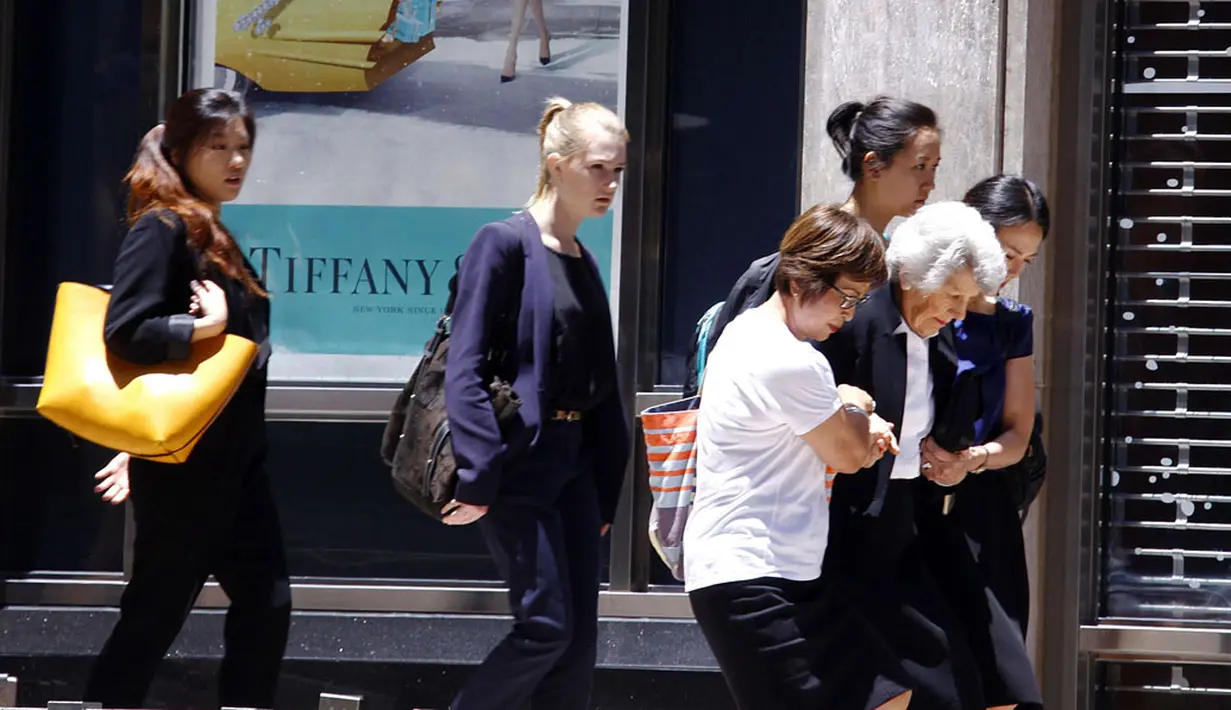 Beberapa orang membantu evakuasi seorang wanita lanjut usia keluar dari gedung yang berada di sebelah kafe Lindt, lokasi terjadinya penyanderaan di Sydney, Australia (15/12/2014). (REUTERS/David Gray)