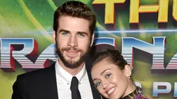 Kemesraan Miley Cyrus dan Liam Hemsworth di karpet merah premier film 'Thor: Ragnarok' di California, 10 Oktober 2017. Miley terlihat begitu manja saat meletakkan kepalanya di pundak pemain film THE HUNGER GAMES itu. (Rich Polk/Getty Images/AFP)