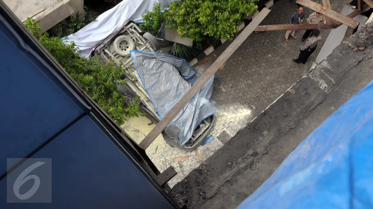 Toyota Kijang warna merah marun yang jatuh dari lantai 3 Direktorat Jenderal Migas, Jakarta, Selasa (5/4). Mobil itu menabrak dinding pembatas di lantai 3 dan kemudian jatuh terbalik. (Liputan6.com/Helmi Affandi)