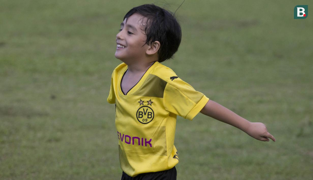 Anak dari Stefano Teco, yang bernama Romario, bermain saat latihan Persija Jakarta di Lapangan Sutasoma, Jakarta, Minggu (25/2/2018). Ketika ayahnya bekerja sang anak asyik bermain sepak bola. (Bola.com/Aspirilla Dwi Adha)