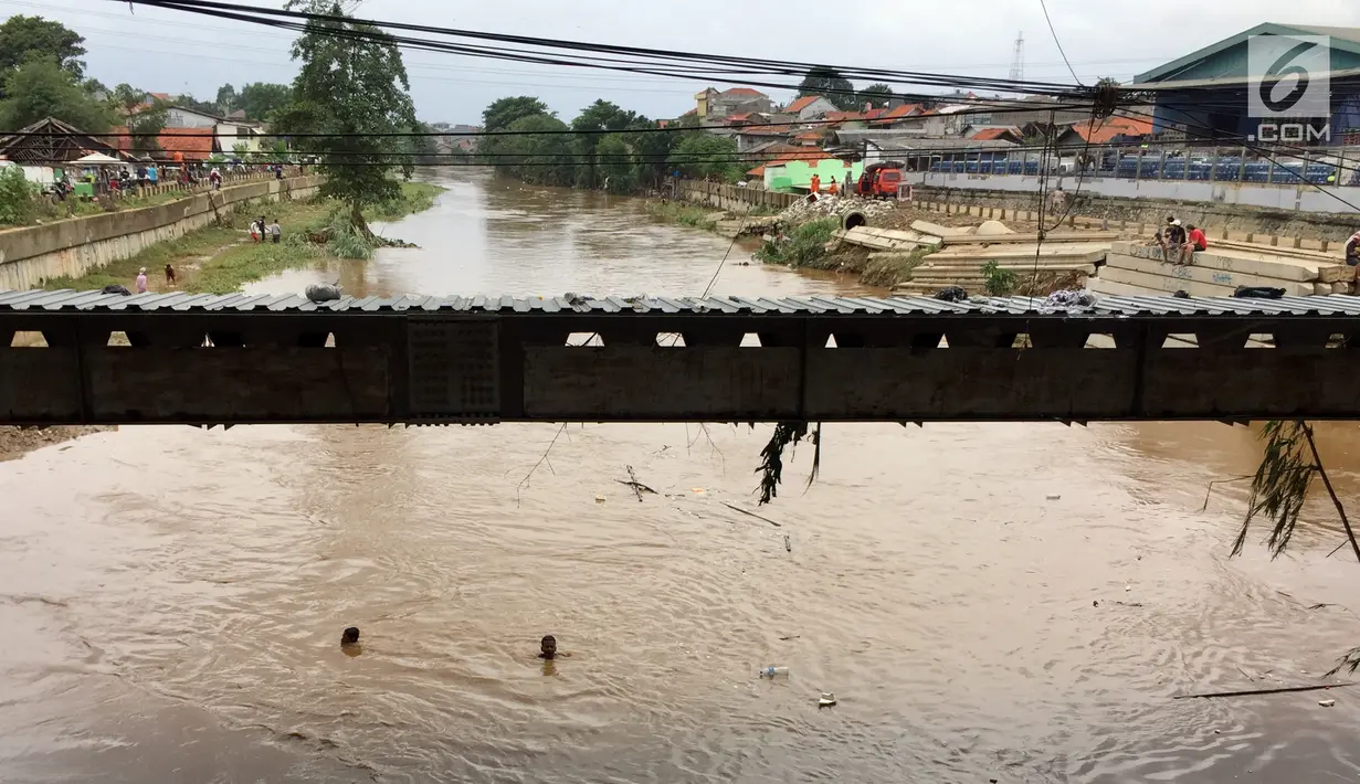 Anak-anak berenang di derasnya arus Sungai Ciliwung, Rawajati, Jakarta, Selasa (6/2). Meski sedang meluap, hal tersebut tidak menyurutkan niat anak-anak untuk berenang. (Liputan6.com/Immanuel Antonius)