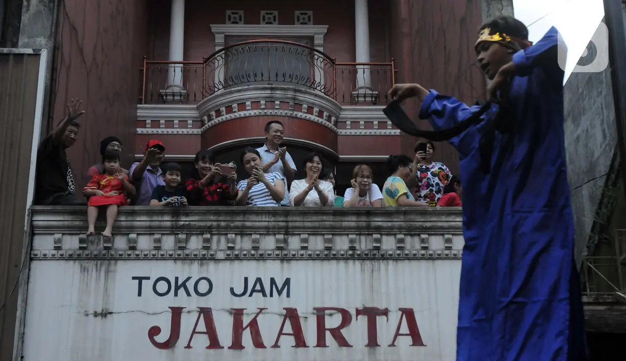Warga menyaksikan pawai Bogor Street Festival Cap Go Meh (CGM) 2020 yang digelar di Jalan Surya Kencana, Kota Bogor, Jawa Barat, Sabtu (8/2/2020). Festival bertema "Ajang Budaya Pemersatu Bangsa" dimeriahkan 25 kelompok barongsai-liong dan beragam tarian daerah. (Liputan6.com/Helmi Fithriansyah)