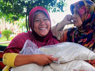 Kegembiraan terpancar usai mendapat beras saat operasi pasar beras oleh BULOG di Lenteng Agung, Jakarta, Senin (2/3/2015). Operasi ini digelar sebagai upaya menurunkan harga beras yang terus naik.(Liputan6.com/Yoppy Renato)