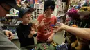 Dua orang anak memainkan fidget spinner di sebuah yang bernama toko Funky Monkey Toys di Oxford, Mich (11/5). Fidget spinner adalah sebuah mainan kecil yang bisa diputar dengan jari. (AP Photo / Carlos Osorio)