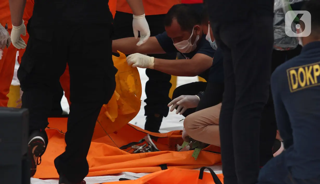 Tim DVI Polri memeriksa serpihan pesawat Sriwijaya Air SJ 182 di Dermaga JICT 2, Jakarta, Minggu (10/1/2021). Tim selam Marinir TNI AL berhasil menemukan dan mengevakuasi serpihan Sriwijaya Air SJ 182 yang kemudian diserahkan ke Basarnas, Kepolisian, serta KNKT. (Liputan6.com/Helmi Fithriansyah)