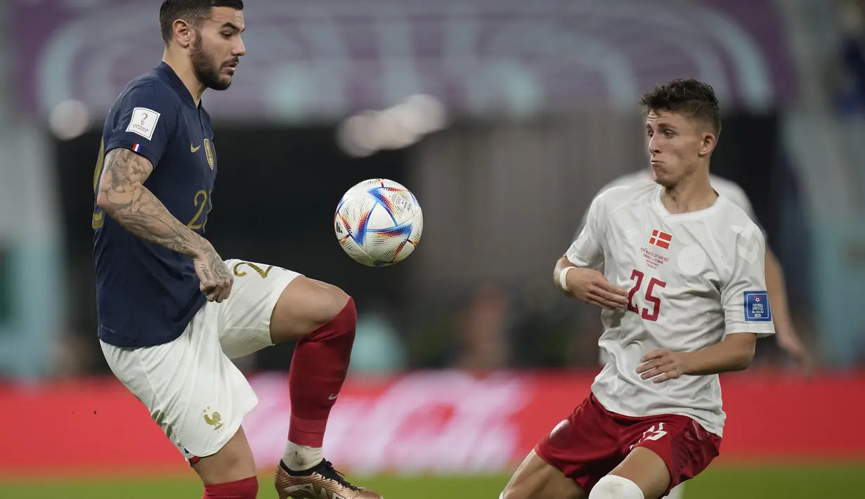 Bek Prancis, Theo Hernandez mengontrol bola dari kawalan pemain Denmark, Jesper Lindstrom selama pertandingan grup D Piala Dunia 2022 Qatar di Stadion 974 di Doha, Qatar, Sabtu, 26 November 2022. Prancis menutup laga kontra Denmark dengan skor 2-1 dan jadi tim pertama yang menembus 16 besar Piala Dunia 2022 Qatar. (AP Photo/Christophe Ena )