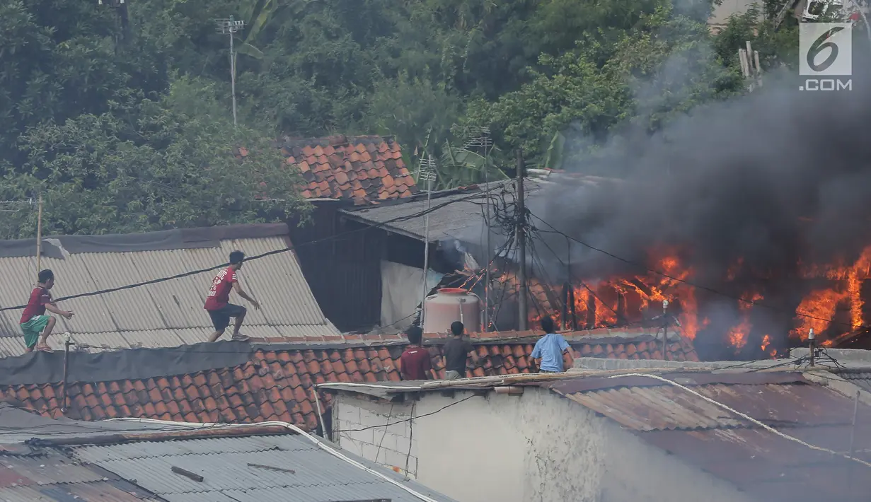 Warga mencoba memadamkan api yang membakar pemukiman padat penduduk di kawasan Manggarai, Jakarta, Rabu (10/7/2019). Tidak ada laporan korban dalam kebakaran ini, sementara kerugian yang diderita masih dalam penanganan petugas di lokasi. (Kapanlagi.com/Budy Santoso)