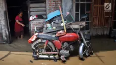 Warga berada di rumahnya yang tergenang banjir di kawasan Sawah besar Semarang, Jawa Tengah, Sabtu (8/12). Ratusan rumah tergenang banjir akibat Tanggul Sungai Banjir Kanal Timur jebol. (Liputan6.com/Gholib)