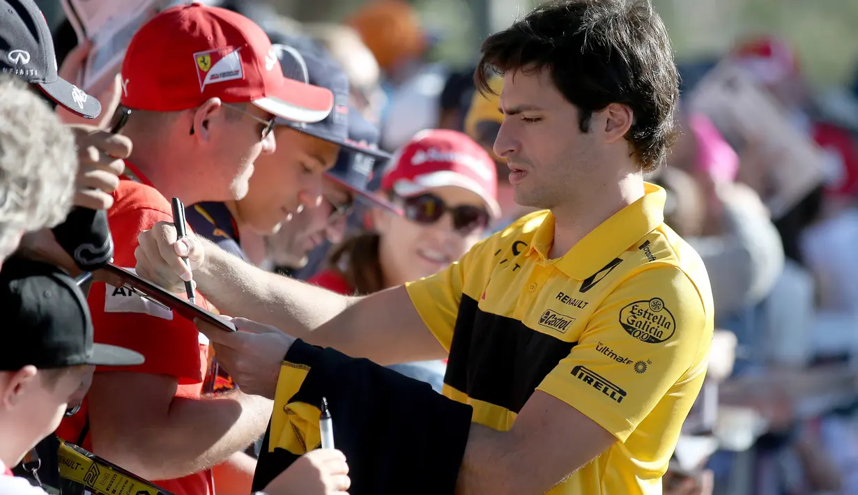 Pembalap tim Renault Carlos Sainz Jr. memberikan tanda tangan kepada fans sesaat sebelum latihan bebas Formula 1 (F1) GP Australia di Melbourne, Jumat (23/3). Balapan F1 GP Australia 2018 sendiri akan bergulir pada Minggu, 25 Maret besok (AP/Rick Rycroft)