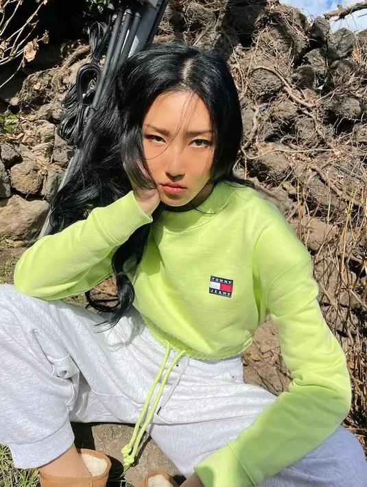 Ingin lebih berwarna? Coba tiru style hip hop ala Hwasa Mamamoo satu ini. Padukan crop top warna hijau neon dengan sport pants. (Instagram/_mariahwasa).