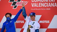 Pembalap Suzuki Ecstar, Joan Mir (kanan) merayakannya dengan Manajer Tim Davide Brivio setelah memenangkan kejuaraan dunia MotoGP setelah Grand Prix Valencia di sirkuit Ricardo Tormo di Valencia  (15/11/2020). (AFP/Lluis Gen)