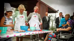 Ekspresi Pangeran Charles saat membuat kue lamington bersama anak-anak di Brisbane, Australia, Rabu (4/4). Pangeran Charles dan Camilla menunjungi Australia untuk menghadiri pembukaan Gold Coast Commonwealth Games 2018. (Patrick HAMILTON/POOL/AFP)