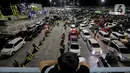 Seorang anak memperhatikan antrean mobil yang akan masuk ke dalam kapal penyeberangan di Pelabuhan Merak, Kota Cilegon, Banten, Jumat (28/3/2025) dini hari. (Liputan6.com/Herman Zakharia)