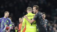 Pemain Bayern Munchen, Harry Kane, menghibur kiper Celtic, Kasper Schmeichel, setelah leg pertama play-off 16 besar Liga Champions 2024/2025 di Celtic Park Stadium, Glasgow, Kamis (13/2/2025) dini hari WIB. Bayern Munchen menang 2-1 atas Celtic dalam laga ini. (AP Photo/Scott Heppell)