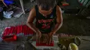 Pekerja menyelesaikan pembuatan petasan di sebuah pabrik di Bocaue, Bulacan, Filipina, Jumat (27/12/2019). Petasan-petasan tersebut akan dijual untuk perayaan Tahun Baru 2020. (Maria TAN/AFP)