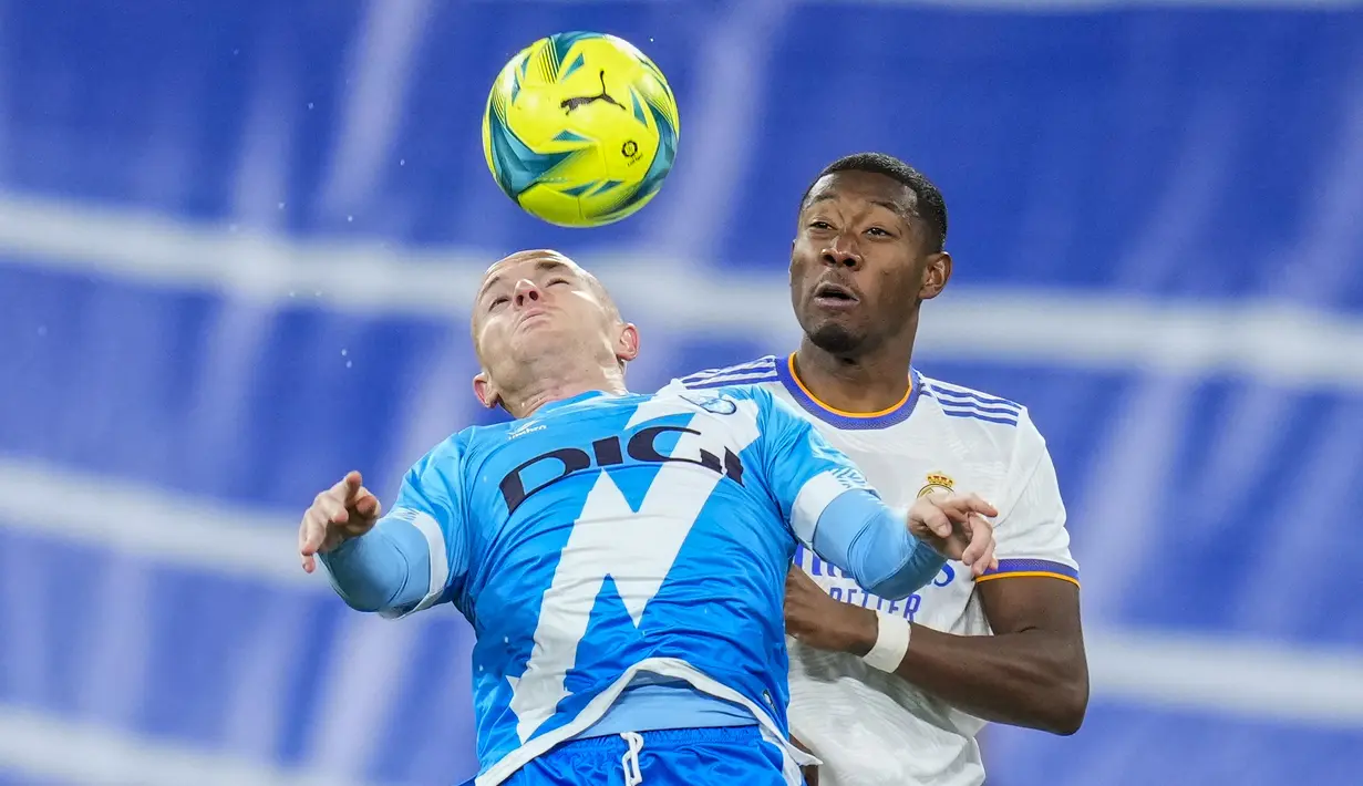 Penyerang Rayo Vallecano, Isi Palazon berebut bola dengan bek Real Madrid David Alaba pada pekan ke-13 Liga Spanyol 2021/22 di Santiago Bernabeu, Minggu (7/11/2021) dini hari WIB. Real Madrid berhasil mengantongi tiga poin setelah menekuk Rayo Vallecano 2-1. (AP Photo/Manu Fernandez)